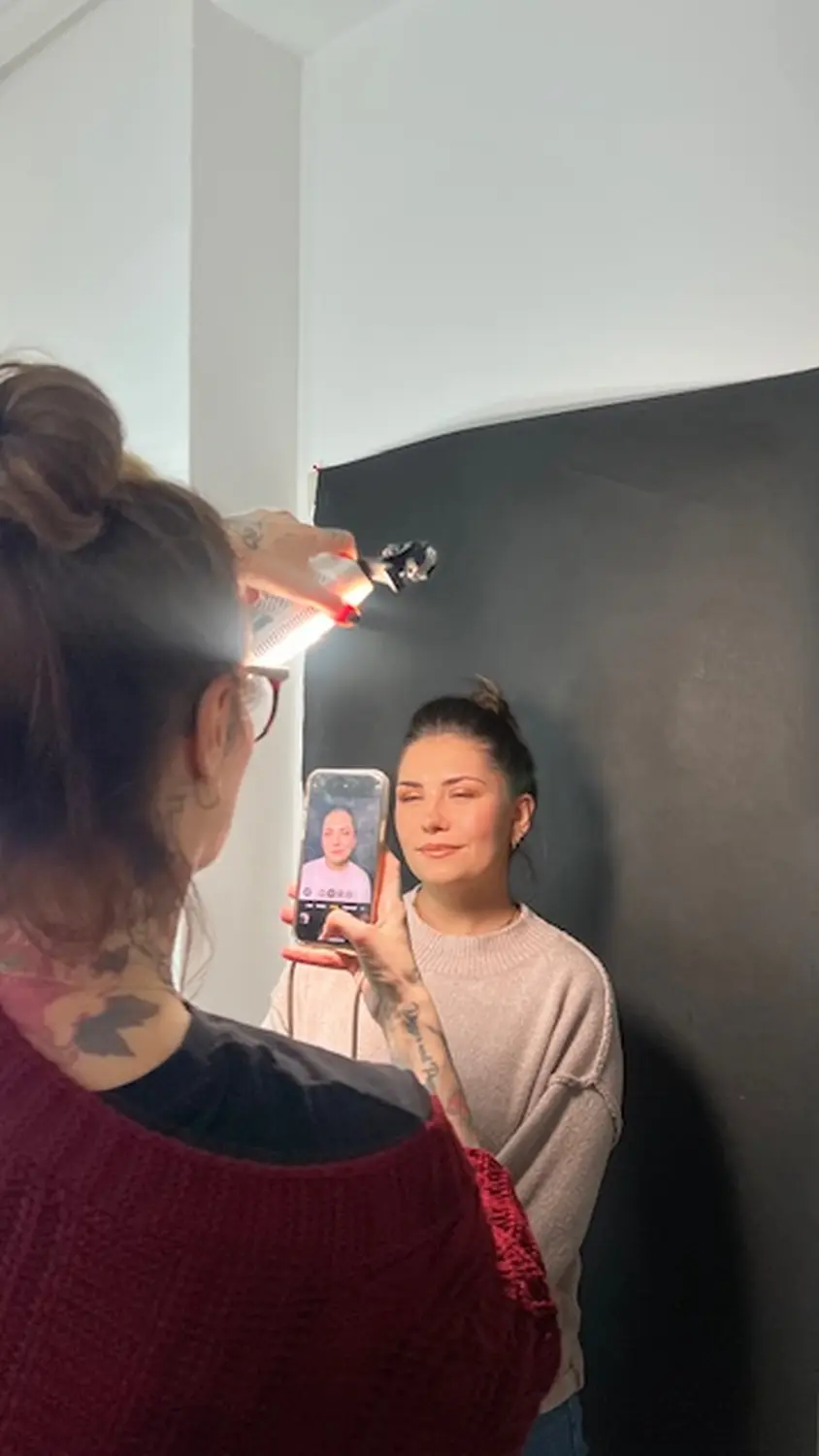 Frau klickt auf Foto einer anderen Frau von Manipura Cosmetic & Wellness